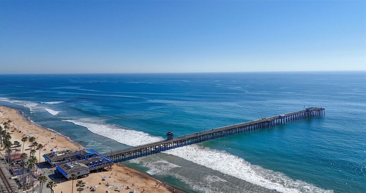 Aerial view of the pier stretching into deep blue water