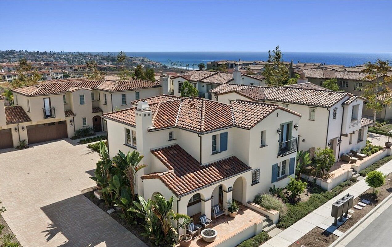 Spanish-style homes with red tile roofs in Sea Summit with the ocean beyond