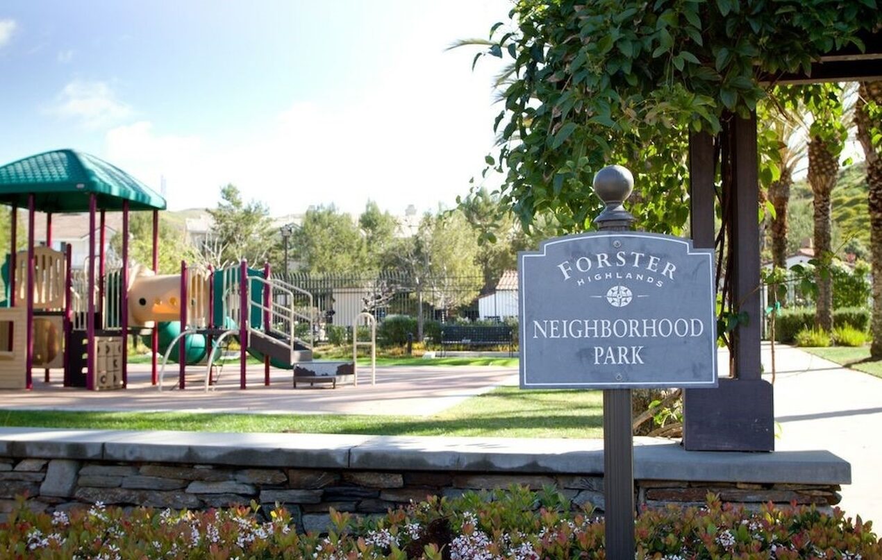Forster Highlands Neighborhood Park sign beside a playground and lawn in Forster Ranch, San Clemente